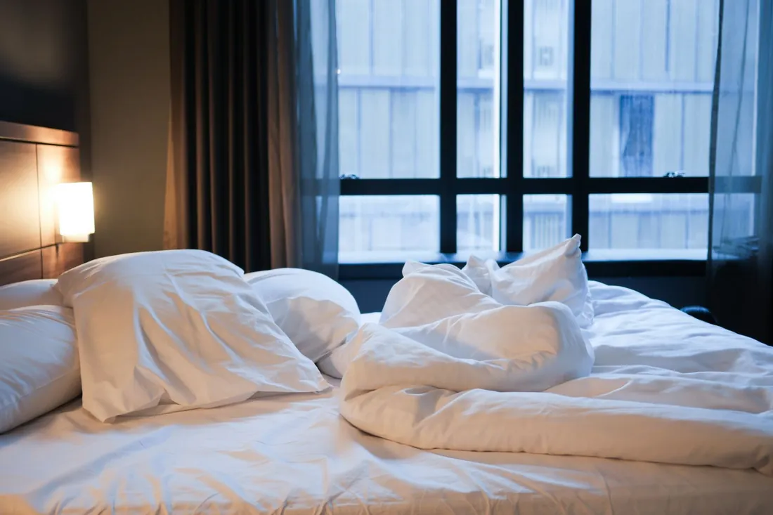 Crisp white hotel bed, one reason people sleep better in hotels