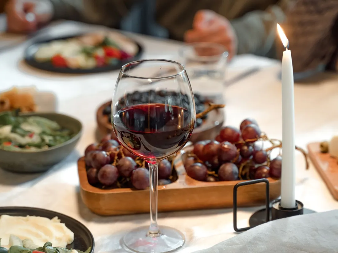 Holiday dinner table with wine and shared dishes, a common reason people sleep hot afterward